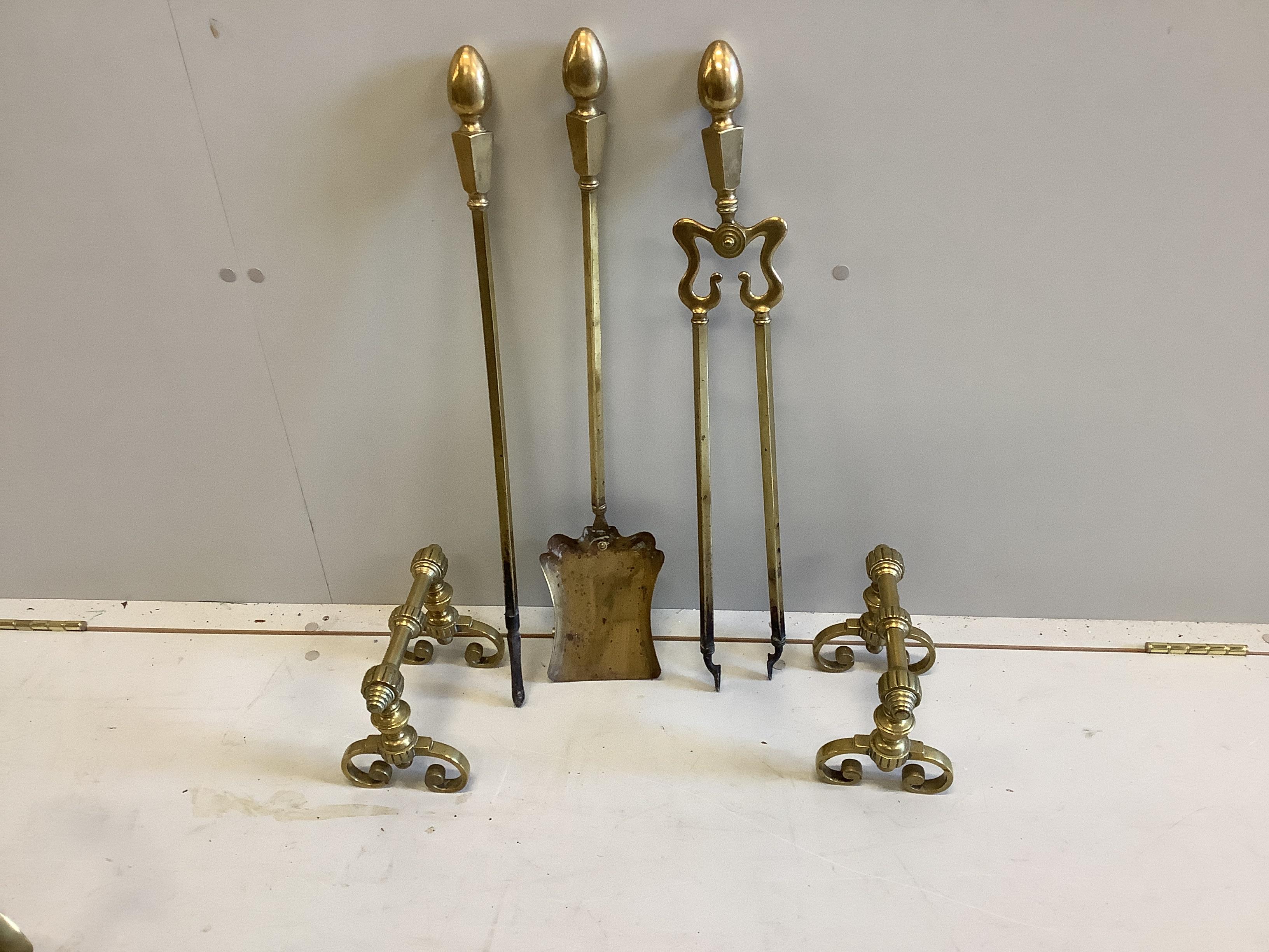 A Victorian Art Nouveau brass fender, length 136cm together with a set of three implements and a pair of firedogs